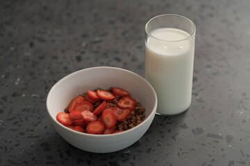 Organic oat granola with strawberry and yogurt on concrete background