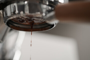 Extracting espresso with naked portafilter closeup