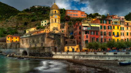 Fototapeta na wymiar Late afternoon sunshine hitting the buildings around the harbour of Vernazza in Italy's Cinque Terre