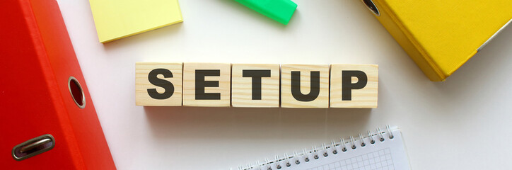 Wooden cubes with word SETUP on the office desk.