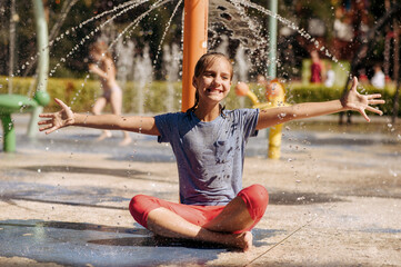Little girl sitting in yoga pose, water playground © Nomad_Soul