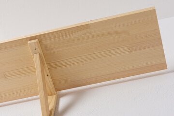 The process of attaching a wooden shelf to the wall, shelf corners together with a bookshelf