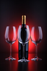 wine bottle and glasses with black background and red