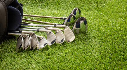 Golf sticks on green grass golf course, close up view.