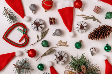 Christmas composition with New Year decorations, balls, stars, tree, Santa hat, spruce branches and sweets on white background. View from above. Holiday, winter concept. Flat lay, top view, copy space