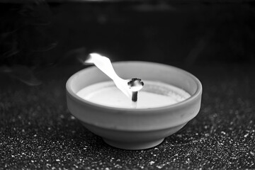 A candle burning on a grave in the cemetery of All Saints' Day