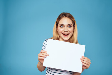 Naklejka premium Emotional woman holding a sheet of paper in her hands lifestyle close-up blue background Copy Space