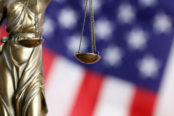 Symbolbild: Justitia vor einer USA-Flagge.