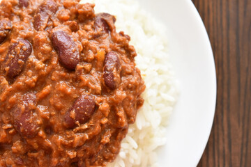 Chilli con carne with rice on a white plate.