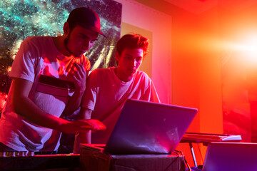 two Disc jockey or DJ stands behind the sound mixing console, makes sound at the party