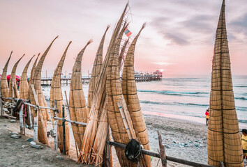 The view to the caballitos de totora ( totora horseboat) on the sunset at huanchaco beach in the...