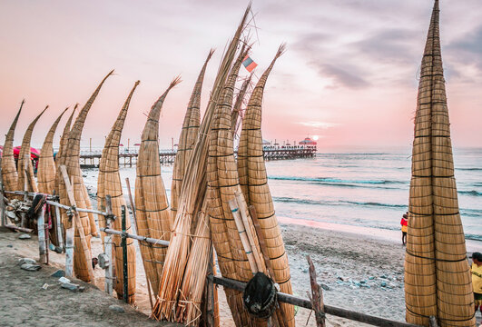 The view to the caballitos de totora ( totora horseboat) on the sunset at huanchaco beach in the peruvian coast near trujillo - Peru