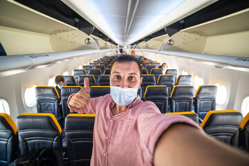 handsome man tourist wearing mask taking a selfie in airport before journey taking flight, Communicate about health and safety measures in commonly used spaces, in times of covid coronavirus pandemic