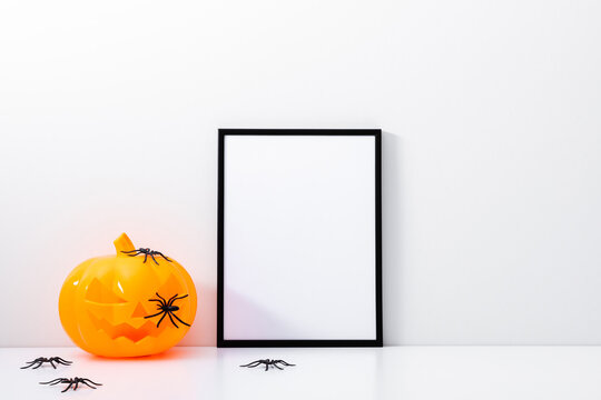Halloween holiday concept. Photo frame, pumpkin, halloween decorations on white background. Front view, copy space