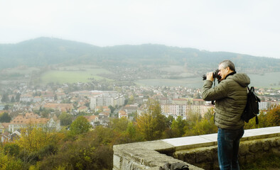 a man photographs a city in a valley