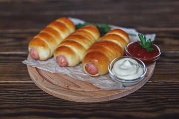 Dishes made of dough, sausages in the dough. Delicious food. Beautiful table setting.
