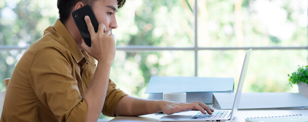 Young Asian men work at home to prevent COVID-19 infection