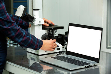 Front view worker analyzing with microscope.