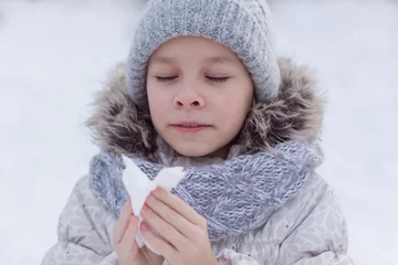 Deurstickers Meisje met allergie symptoom blazende neus. Tienermeisje die een weefsel in een de winterpark gebruiken. © Albert Ziganshin