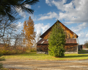 Fototapeta premium barn with diamond-shaped window and green and orange trees