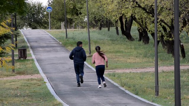 Pareja de corredores en un camino y jugando. Plano general