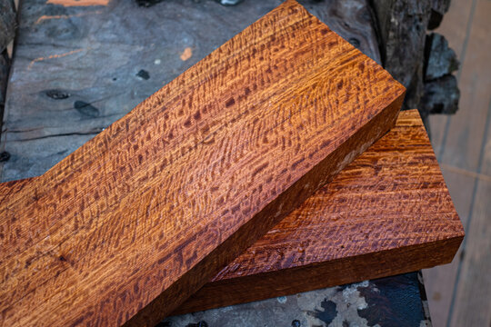 Burma padauk wood has tiger stripe or curly stripe grain on the table at blurred background
