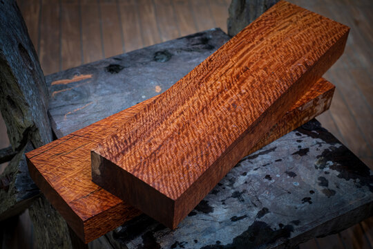 Burma padauk wood has tiger stripe or curly stripe grain on the table at blurred background