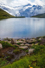 Naklejka na ściany i meble Jungfrau mountain in the distance at a lake near First, Switzerland. 