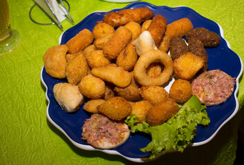 Gastronomic photograph of a portion of children's party snacks. Much consumed in Brazil. Fried Onion, Mini Pizza, Chicken drumstick, meat drumstick, sfiha. Fried salts and baked goods.