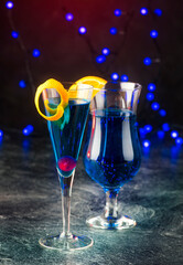 Traditioneller Cocktail Vulcano mit blauen Curacao und Champagner angeboten als close-up in Design Gläser