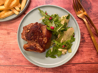 Beef rump steak fillet with french fries and green salad.