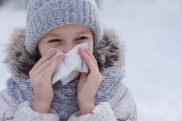 Poster Meisje met allergie symptoom blazende neus. Tienermeisje die een weefsel op een witte achtergrond gebruiken. © Albert Ziganshin