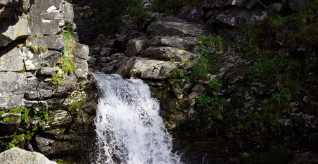 Beautiful waterfall in the mountains among the rocks