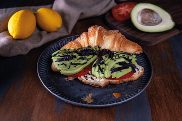 Hearty croissant with avocado and tomato