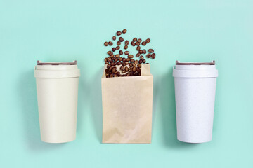 Reusable eco coffee cup, metal drinking straw, roasted coffee beans.