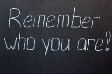 
The inscription on a dark chalk board Remember who you are. Wisdom of life