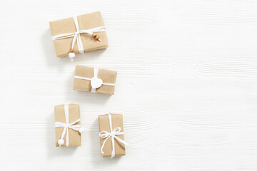 Homemade gifts, Christmas present boxes wrapped in kraft paper, on white wooden table with copy space