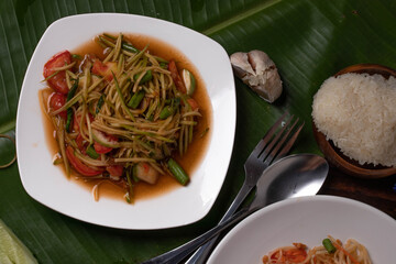 Papaya salad with mango, rubber chicken and sticky rice. Popular food in Thailand.