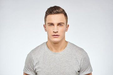 man in gray t-shirt emotions light background cropped view