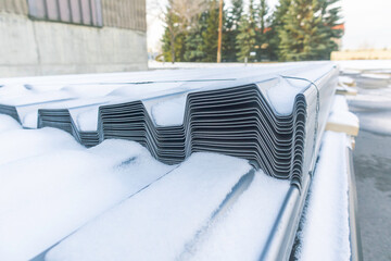 stack of corrugated metal roofing outside in winter
