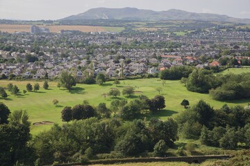 Naklejka premium Green fairways on golf course bordering city