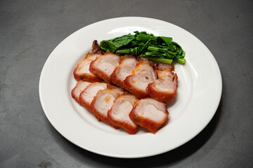 roast barbecue red pork or Cantonese barbecued pork with vegetable - chinese style on white plate.