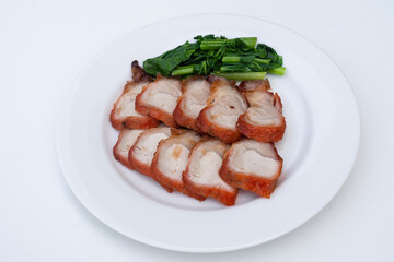 roast barbecue red pork or Cantonese barbecued pork with vegetable - chinese style on white plate.