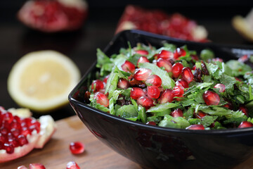 Tabbouleh with pomegranate. Green salad of parsley and herring with large pomegranate grains, in a...