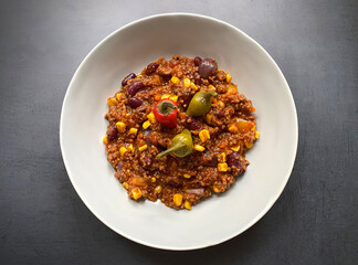 Chili con carne with minced beef, tomatoes, chilli peppers, beans, corn, onions, garlic and bell pepper.
