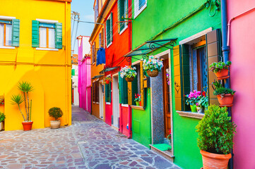 Fototapeta na wymiar Colorful architecture in Burano island, Venice, Italy. Cozy courtyard with flowers. Famous travel destination