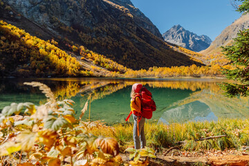 Hiker woman at lake in the autumnal mountains. Mountain lake and tourist © artifirsov