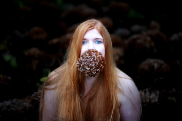 Portrait of a young lovely sexy redheaded woman with free shoulders, and long red hair with a...