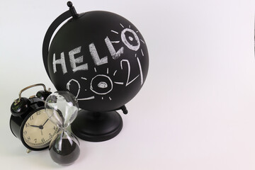 Hello 2021 , Happy New Year
Black Globe with Wording " Hello 2021 " , Alarm Clock , Hour Glass , 2 Black Books , White Background