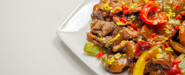 Cooked marinated beef slices with a savory black beef sauce, peppers and onions